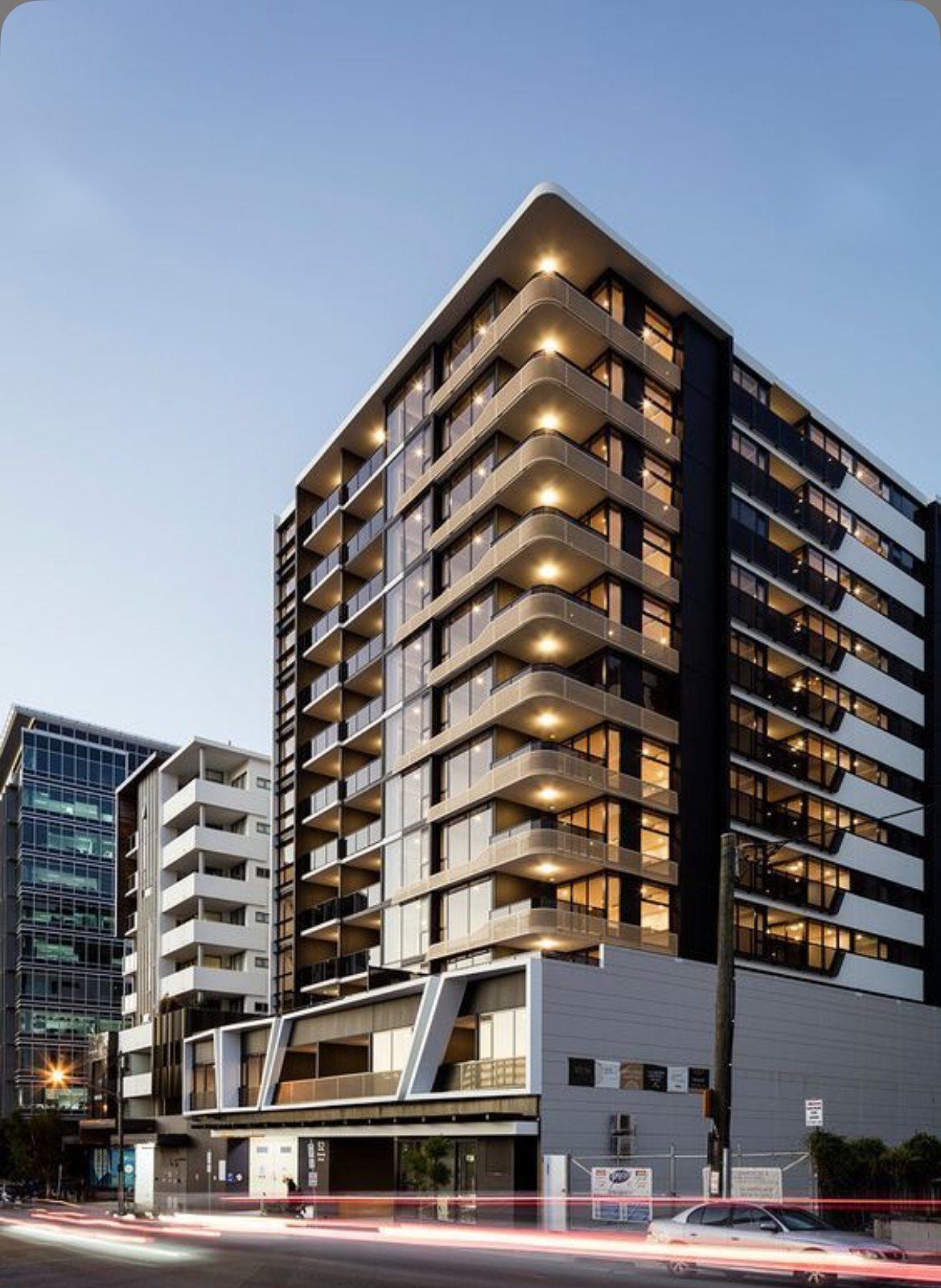 Edifício residencial moderno com varandas iluminadas ao entardecer